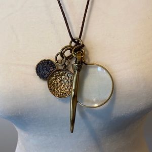 Brass charms on leather cord.